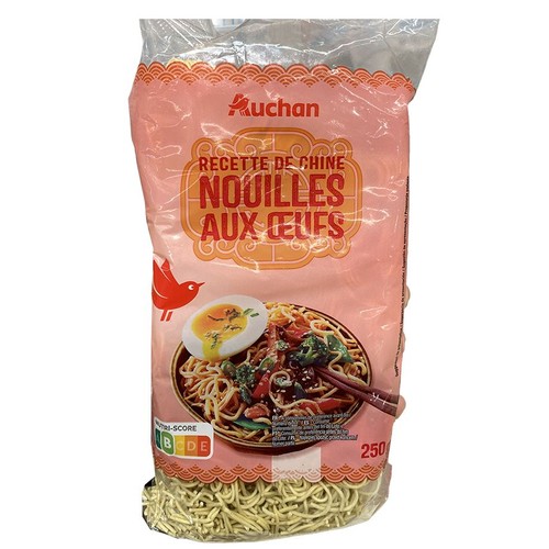 Kluski jajeczne Auchan "Recette de Chine" w przezroczystym opakowaniu, 250g. Widoczne suche kluski i grafika dania.
