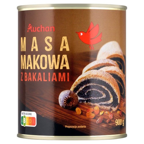 Brązowa puszka masy makowej Auchan z bakaliami, o wadze 900g. Na etykiecie widnieje nazwa produktu, logo Auchan (czerwony ptak) oraz apetyczna grafika przedstawiająca pokrojony makowiec, suszone figi i rodzynki jako propozycja podania.