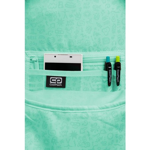 Zbliżenie na miętową kieszeń plecaka z zamkiem błyskawicznym. W kieszeni umieszczono biały smartfon oraz dwa długopisy CoolPack w kolorach niebieskim i zielonym. Na froncie kieszeni widnieje czarne logo CP CoolPack. Tkanina plecaka ma delikatny wzór.