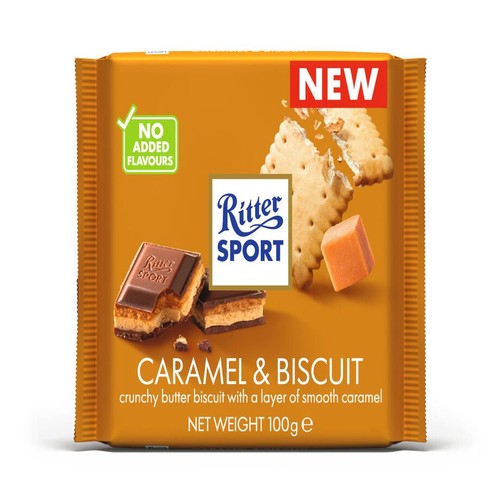 Opakowanie czekolady Ritter Sport Caramel & Biscuit 100g. Widoczne kawałki czekolady z warstwą karmelu i chrupiącego herbatnika. Na opakowaniu informacja o nowości i braku dodanych aromatów.