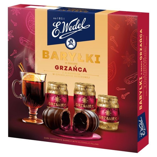Pudełko czekoladek E.Wedel Baryłki Grzańca. Na opakowaniu grafika szklanki grzanego wina z pomarańczą i cynamonem. Widoczne czekoladki deserowe z alkoholowym nadzieniem o smaku grzańca, w tym dwie przekrojone.