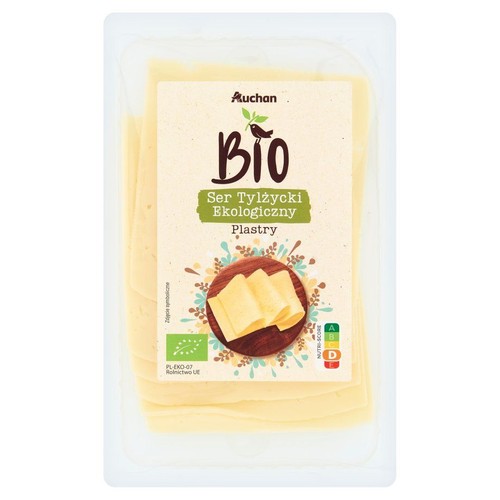 Ser Tylżycki Ekologiczny Auchan Bio w plastrach. Produkt w przezroczystym opakowaniu, z widocznymi żółtymi plastrami.