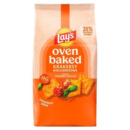 Pomarańczowa paczka krakersów Lay's Oven Baked z 35% pełnego ziarna, o smaku pomidora i bazylii. Widoczne krakersy, pomidory, bazylia.