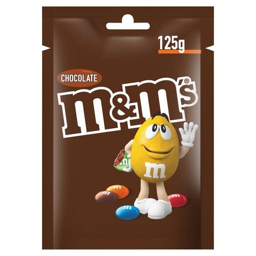 Brązowa torebka czekoladowych drażetek M&M's o wadze 125g. Na opakowaniu widnieje duża grafika żółtej postaci M&M's, która macha ręką. Wokół niej leżą kolorowe drażetki w odcieniach czerwieni, niebieskiego, pomarańczu i brązu.
