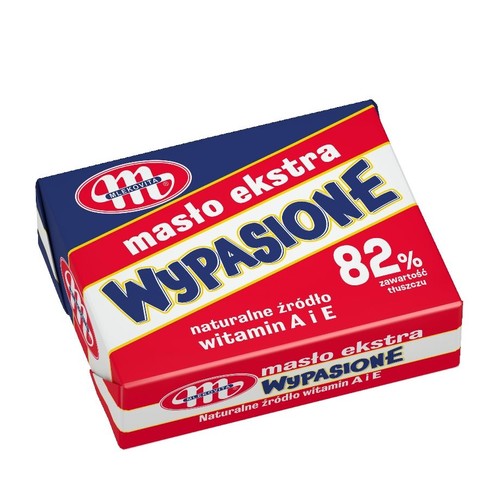 Produkt spożywczy: masło ekstra Wypasione Mlekovita. Opakowanie w kształcie kostki, z czerwonym tłem i niebieskim paskiem. Wyraźnie widoczna informacja o 82% zawartości tłuszczu i naturalnym źródle witamin A i E.