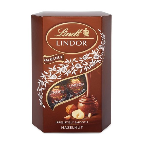 Czekoladki Lindt Lindor Hazelnut w brązowym, sześciokątnym pudełku. Na froncie logo Lindt, nazwa produktu i grafika pralin z kremowym nadzieniem oraz orzechów laskowych.