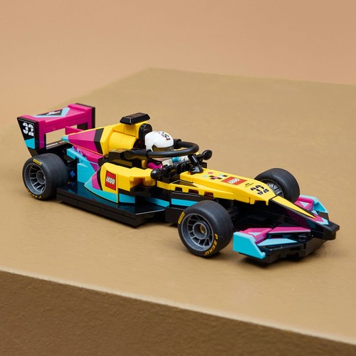Model bolidu wyścigowego LEGO, dominują kolory żółty i czarny, uzupełnione o jaskrawe różowe i błękitne detale. Na tylnym skrzydle widnieje numer 32. W kokpicie siedzi figurka kierowcy w białym kasku.