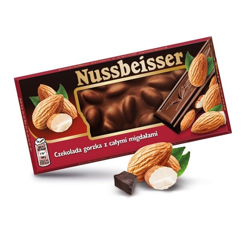 Produkt Nussbeisser: czekolada gorzka z całymi migdałami w prostokątnym, czerwonym opakowaniu. Na opakowaniu grafika czekolady z migdałami. Obok opakowania ułożono migdały i kostkę czekolady.