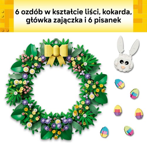 Wieniec wielkanocny zbudowany z klocków LEGO, z zielonymi liśćmi, różnobarwnymi kwiatami w odcieniach żółci, różu, fioletu i bieli. Na górze żółta kokarda. Obok biała głowa zajączka i 6 kolorowych pisanek.