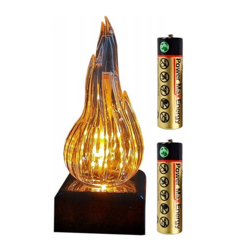 Lampa stołowa LED w formie płomienia, z licznymi, jasnymi diodami LED wewnątrz, tworzącymi efekt migoczącego ognia. Podstawa lampy jest czarna i kwadratowa. Do zestawu dołączono dwie cylindryczne baterie Power Max Energy w złotym kolorze.