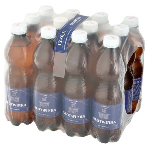 Zgrzewka 12 brązowych, plastikowych butelek wody leczniczej SŁOTWINKA, każda o pojemności 500 ml. Buteleczki mają białe zakrętki i niebieskie etykiety z grafiką budynku i napisem "Woda lecznicza". Całość owinięta folią.
