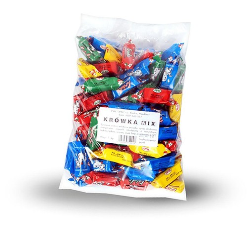 Przezroczysta torebka z cukierkami Krówka Mix o wadze 1 kg. Cukierki w kolorowych papierkach: czerwonym, niebieskim, żółtym i zielonym.