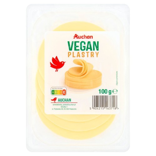 Auchan Wegańskie plastry, 100 g, w przezroczystym opakowaniu. Jasnożółte, okrągłe plastry ułożone jeden na drugim.