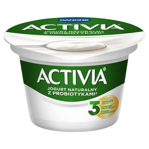 Kubek jogurtu naturalnego Activia z probiotykami. Zielona etykieta z logo Danone. Na wieczku łyżka z jogurtem.