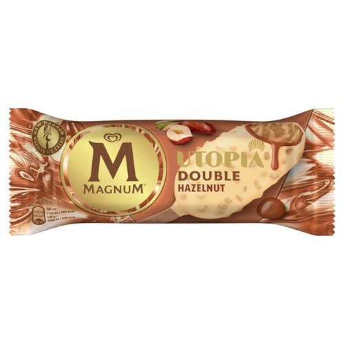 Opakowanie lodów Magnum Utopia Double Hazelnut, 80 ml. Na brązowo-złotym tle grafika loda na patyku, pokrytego białą czekoladą z kawałkami orzechów laskowych i polewą. Obok widoczne całe i połówki orzechów.