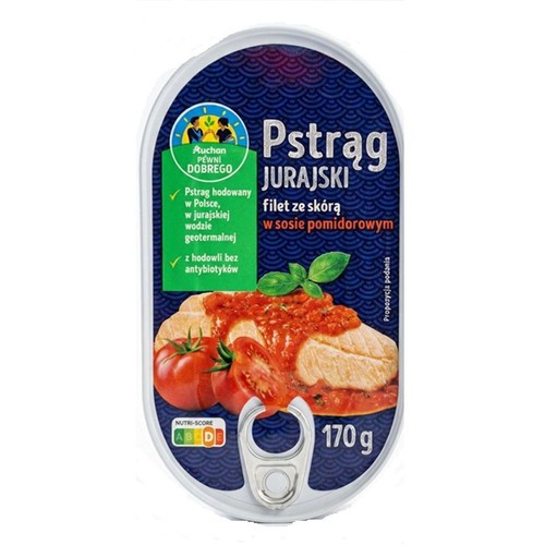 Owalna puszka Pstrąg Jurajski Auchan 170 g. Zawiera filet ze skórą w sosie pomidorowym. Na niebieskiej etykiecie grafika przedstawiająca kawałki ryby polane sosem, z pomidorami i bazylią. Pstrąg hodowany w Polsce, bez antybiotyków.