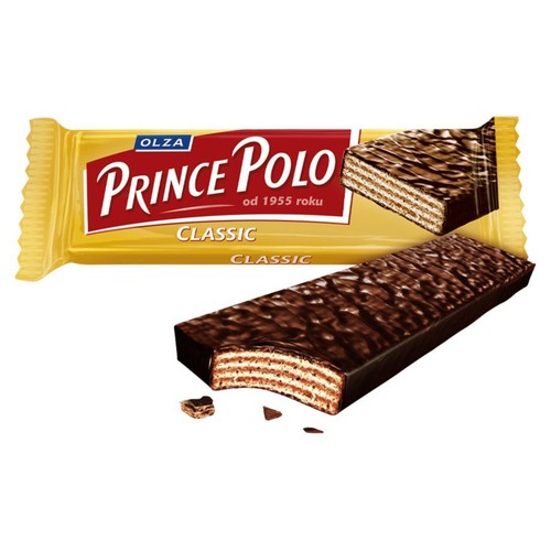 Baton waflowy Prince Polo Classic firmy Olza w żółtym opakowaniu. Obok leży baton z ciemną czekoladową polewą, z widocznym ugryzieniem ukazującym warstwy wafla i kremu. W tle opakowanie z napisem "od 1955 roku".