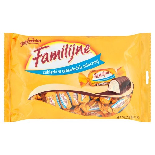 Żółta torebka cukierków Jutrzenka Familijne w czekoladzie mlecznej, waga netto 1 kg. Widoczny przekrój cukierka z jasnym nadzieniem.