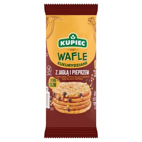 Brązowo-żółte opakowanie wafli kukurydzianych Kupiec Extra Slim. Na etykiecie grafika stosu wafli z jagłą i pieprzem, z widocznymi ciemnymi i jasnymi drobinkami. Produkt bezglutenowy, waga netto 105g.