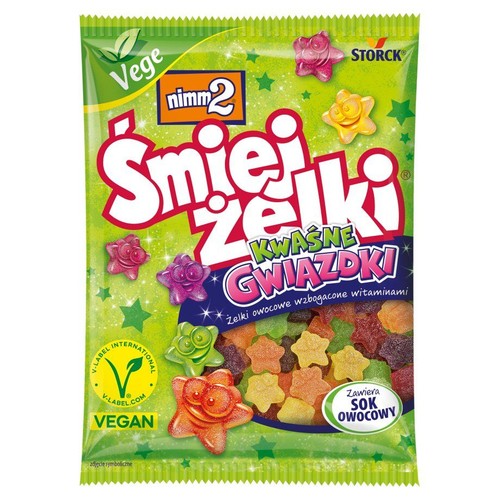 nimm2 Śmiejżelki Kwaśne Gwiazdki w zielonym opakowaniu. Wegańskie żelki owocowe z witaminami i sokiem owocowym. Na opakowaniu widoczne są różnokolorowe żelki w kształcie gwiazdek, niektóre z nich mają twarze.