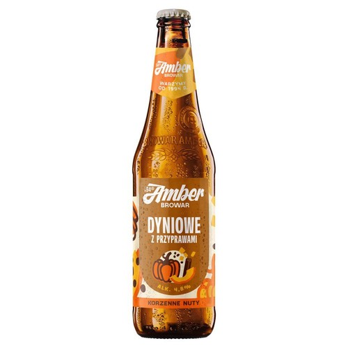 Piwo Browar Amber Dyniowe z przyprawami w szklanej butelce z metalową zakrętką. Etykieta przedstawia dynię, cynamon i anyż. Produkt zawiera 4.8% alkoholu i ma korzenne nuty.
