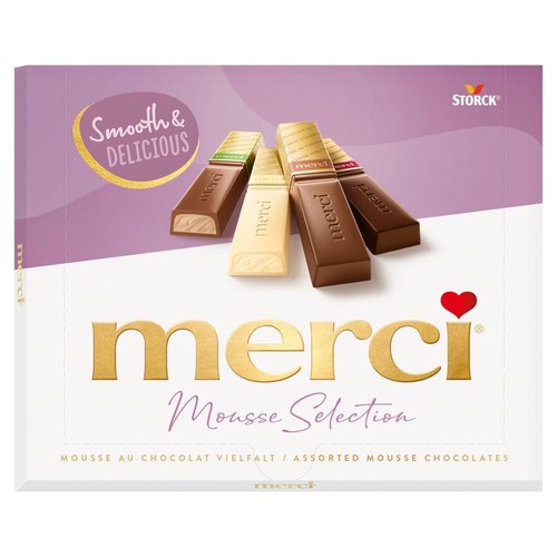 Opakowanie czekoladek Merci Mousse Selection. Widoczne cztery batony czekoladowe w różnych smakach: mlecznej, białej i deserowej. Na pudełku napis "Assorted Mousse Chocolates" (Różnorodne czekoladki z musem).