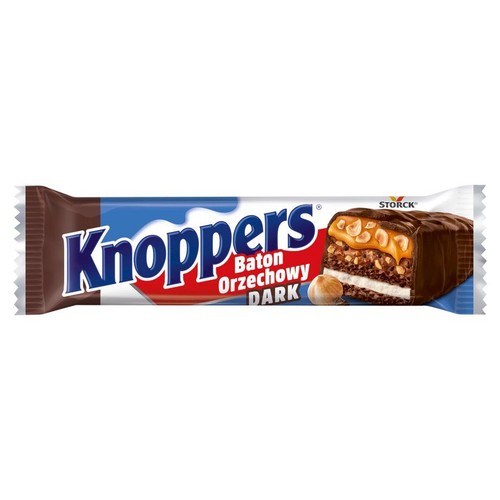 Opakowanie batona Knoppers Baton Orzechowy DARK. Biało-niebieskie opakowanie z logo Knoppers. Na opakowaniu grafika przekrojonego batona, ukazująca warstwy: ciemną czekoladę, karmel, orzechy laskowe, krem i wafle. Obok batona leży orzech laskowy.