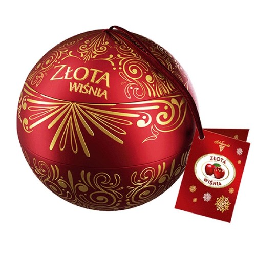 Eleganckie, czerwone opakowanie w kształcie kuli, z napisem "Złota Wiśnia" i misternymi złotymi wzorami. Do opakowania dołączona jest czerwona etykieta z logo "Adamidis", nazwą produktu i ilustracją wiśni, idealne na prezent.