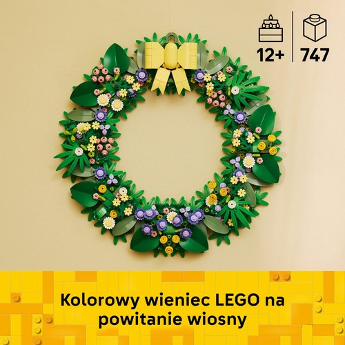 Okrągły wieniec z klocków LEGO, wykonany z zielonych liści i różnorodnych, drobnych kwiatów w kolorach różowym, fioletowym, żółtym i białym. Na górze znajduje się żółta kokarda. Zestaw dla osób od 12 lat, składający się z 747 elementów.