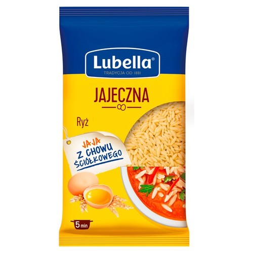 Makaron Lubella Jajeczna Ryż w żółto-niebieskim opakowaniu. Na etykiecie widnieje nazwa produktu, informacja o jajach z chowu ściółkowego oraz czas gotowania 5 minut. Część opakowania jest przezroczysta, ukazując zawartość.