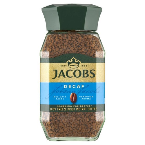 Szklany słoik kawy rozpuszczalnej Jacobs Decaf, 100% liofilizowanej, bezkofeinowej. Na złoto-niebieskiej etykiecie widnieje logo Jacobs, podpis "Johann Jacobs" oraz informacje o delikatnym smaku i bogatym aromacie.