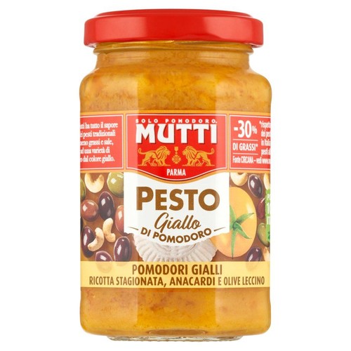 Mutti Pesto Giallo z żółtych pomidorów w szklanym słoiku z czerwoną pokrywką. Etykieta przedstawia składniki: żółte pomidory, dojrzałą ricottę, orzechy nerkowca i oliwki Leccino. Produkt ma 30% mniej tłuszczu.