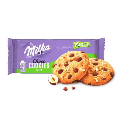 Opakowanie Milka Choco Cookies Nut w kolorze fioletowym. Przed nim dwa okrągłe ciasteczka z kawałkami czekolady i orzechów laskowych. Obok połówka orzecha.