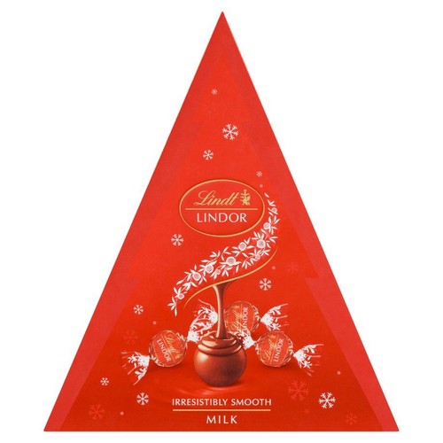 Czerwone, trójkątne opakowanie czekoladek Lindt Lindor Milk. Na pudełku znajduje się logo Lindt Lindor, białe śnieżynki oraz grafika przedstawiająca płynną czekoladę spływającą na truflę, otoczoną trzema zapakowanymi truflami.