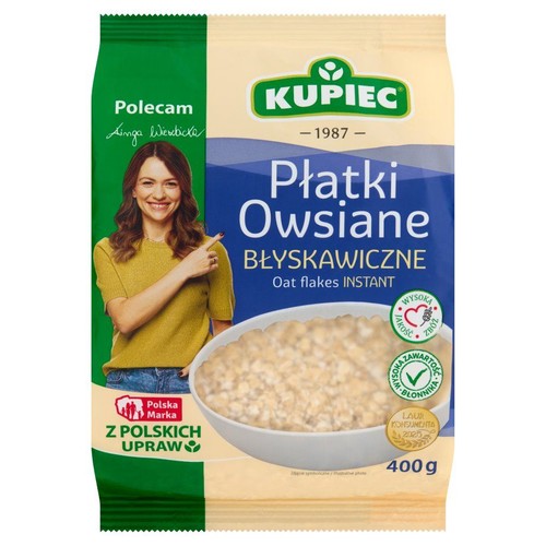 Kupiec Płatki Owsiane Błyskawiczne, 400g. Opakowanie z wizerunkiem kobiety i miską płatków. Wysoka zawartość błonnika.
