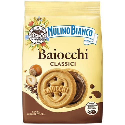 Żółto-brązowe opakowanie ciastek Mulino Bianco Baiocchi Classici. Na opakowaniu widoczne dwa okrągłe ciastka z kremem orzechowo-czekoladowym i orzechy laskowe. Produkt bez oleju palmowego, z orzechami z zrównoważonej uprawy.