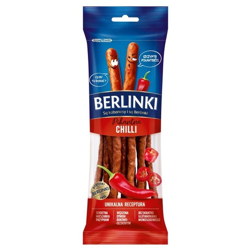 Opakowanie kabanosów Berlinki Pikantne Chilli, drobiowo-wieprzowych, 85g. Na niebiesko-czerwonym tle widoczne są kabanosy oraz ilustracje czerwonych papryczek chili. Produkt wędzony dymem bukowo-olchowym, bez dodatku glutaminianu monosodowego.