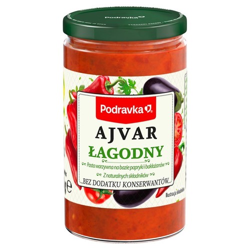 Ajvar łagodny marki Podravka, w słoiku z zieloną zakrętką. Pasta warzywna na bazie papryki i bakłażanów, z naturalnych składników, bez dodatku konserwantów. Etykieta z grafiką warzyw.