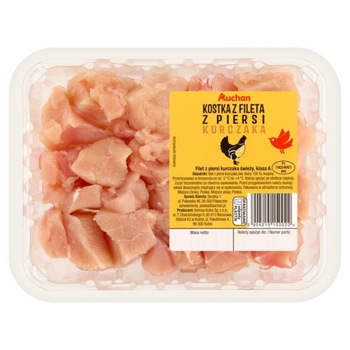 Auchan, kostka z fileta z piersi kurczaka w przezroczystym opakowaniu. Świeże, różowe kawałki mięsa. Żółta etykieta z nazwą produktu.