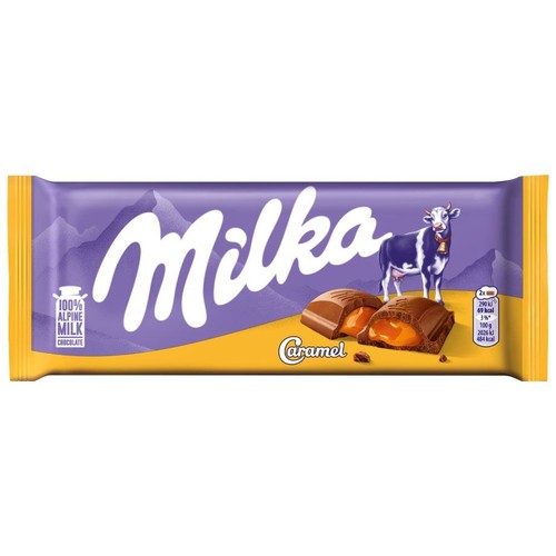 Opakowanie czekolady mlecznej Milka Karmel. Fioletowe tło z górami i logo Milka. Grafika krowy. Na żółtym pasku widoczne dwa rozłamane kawałki czekolady z obfitym, płynnym nadzieniem karmelowym. Napis "100% czekolada z alpejskiego mleka".