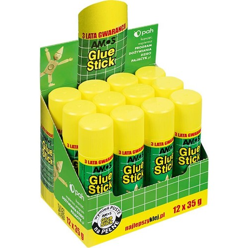 Kartonowy stojak ekspozycyjny z 12 klejami w sztyfcie AMOS Glue Stick, każdy o wadze 35 g. Kleje mają żółte nakrętki i zielone etykiety. Na opakowaniu informacja o 3-letniej gwarancji i wsparciu Programu Dożywiania Dzieci Pajacyk.pl.