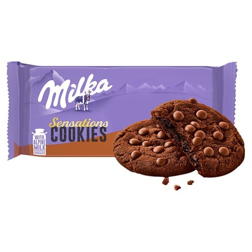 Opakowanie Milka Sensations Cookies z napisem "Z czekoladą z mleka alpejskiego". Obok ciemne ciastka z czekoladowymi dropsami.