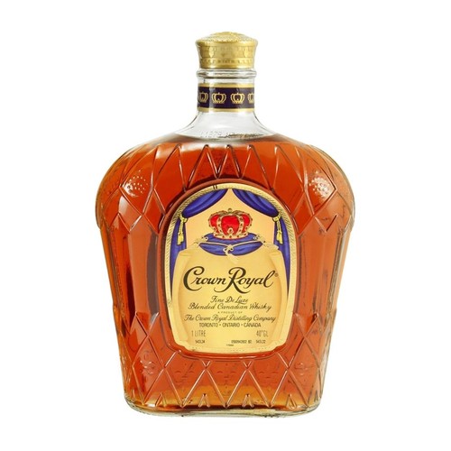 Szklana butelka whisky Crown Royal Fine De Luxe Blended Canadian Whisky. Pojemność 1 litr, 40% obj. alkoholu. Butelka ma fasetowaną powierzchnię i złotą nakrętkę. Etykieta w kolorach złota i błękitu z grafiką czerwonej korony i pełną nazwą produktu.