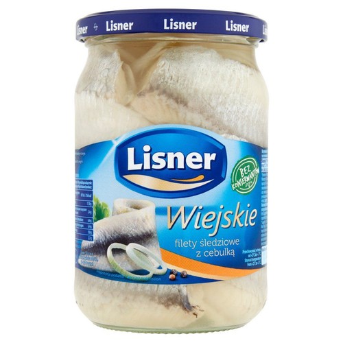 Szklany słoik z filetami śledziowymi Lisner Wiejskie z cebulką. Na niebieskiej etykiecie widnieje nazwa produktu oraz informacja "Bez konserwantów". W tle grafika przedstawiająca śledzie z krążkami cebuli i pieprzem.