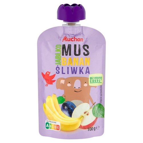 Fioletowa saszetka musu owocowego Auchan Jabłko Banan Śliwka, 100g. Opakowanie z fioletową nakrętką, ozdobione ilustracją uśmiechniętej koali, ptaka oraz bananów, śliwki i przekrojonego jabłka. Produkt bez dodatku cukru.