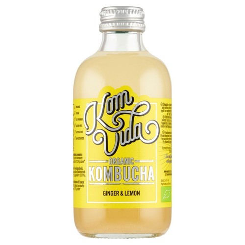 Butelka kombuchy Kom Vida Organic Ginger & Lemon z żółtą etykietą. Na etykiecie widnieje nazwa produktu oraz informacja, że jest to produkt organiczny, surowy, wegański, bezglutenowy i niepasteryzowany. Butelka ma srebrną, metalową zakrętkę.