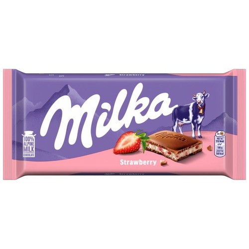 Fioletowe opakowanie czekolady Milka Strawberry z grafiką krowy, gór i przekrojonej truskawki. Widoczny kawałek czekolady z kremem.