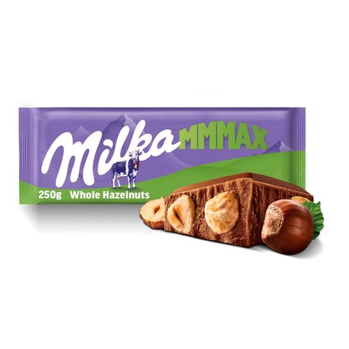 Produkt Milka MMMMAX 250g. Fioletowe opakowanie czekolady z logo Milka i krową. Obok opakowania leży duży, prostokątny kawałek czekolady mlecznej, w którym zatopione są całe orzechy laskowe. Widoczne są też pojedyncze orzechy.