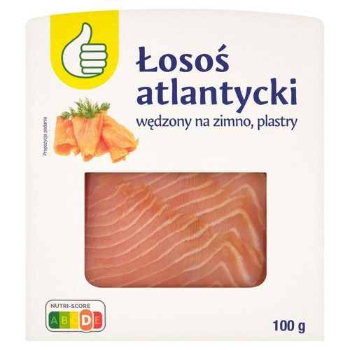 Opakowanie łososia atlantyckiego wędzonego na zimno, w plastrach, 100 g. Na opakowaniu widoczny jest fragment produktu, czyli ułożone plastry łososia. W lewym górnym rogu logo z zielonym kciukiem w górę.