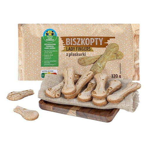 Biszkopty Lady Fingers z płaskurki Auchan 120 g. Widoczne beżowe opakowanie z zieloną etykietą "Auchan Pewni Dobrego" i Nutri-Score A. Kilka podłużnych ciastek leży na szorstkiej, beżowej tkaninie, ułożonej na drewnianej desce.